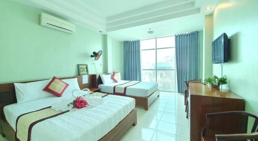 a bedroom with a large bed and a large window, Truong Son Hotel in Ho Chi Minh City