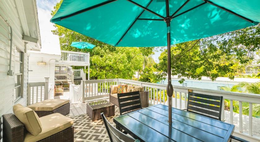 a patio area with a table, chairs and umbrella, Rose Lane Villas in Key West (FL)