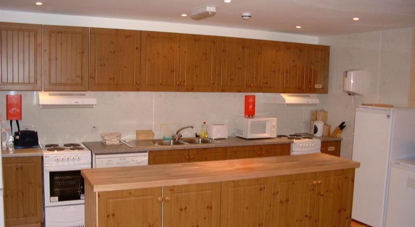 a kitchen with a stove, refrigerator, sink and cabinets, Sandras Backpackers in Thurso