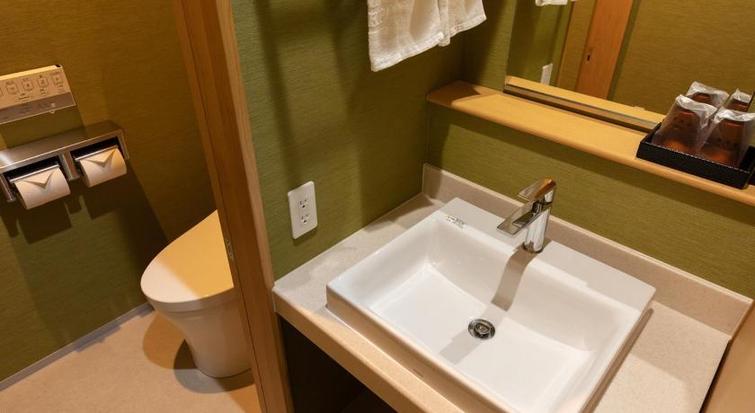 a bathroom with a sink and a toilet, Central Hotel Takeoonsen Ekimae in Takeo