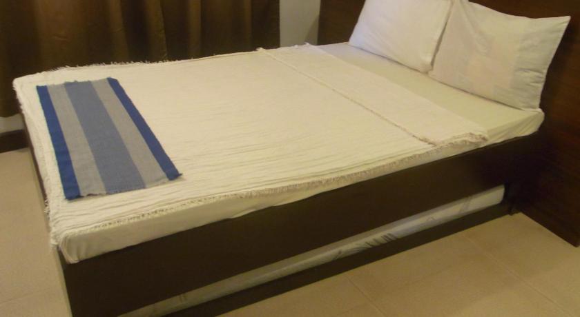 a bed with a white comforter and pillows, Ziur Inn in Ilocos Norte