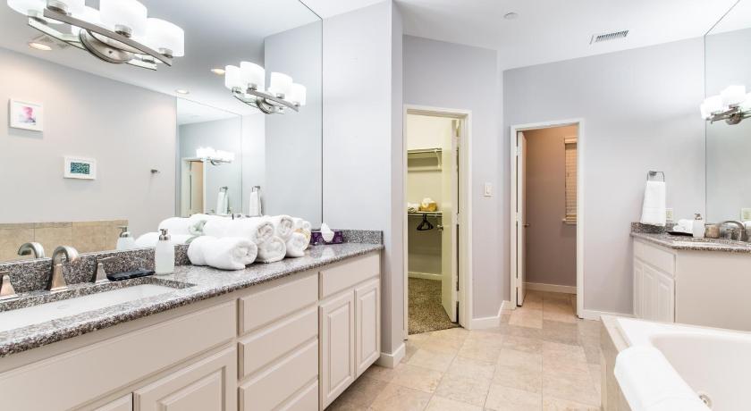 a bathroom with a sink, mirror, and bathtub, DownTown Three Bedroom Townhome Sleeps 8 in Dallas (TX)