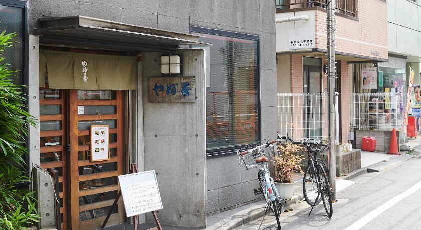 a bicycle parked in front of a store on a sidewalk, Evergreen Hotel Hatsudai in Tokyo