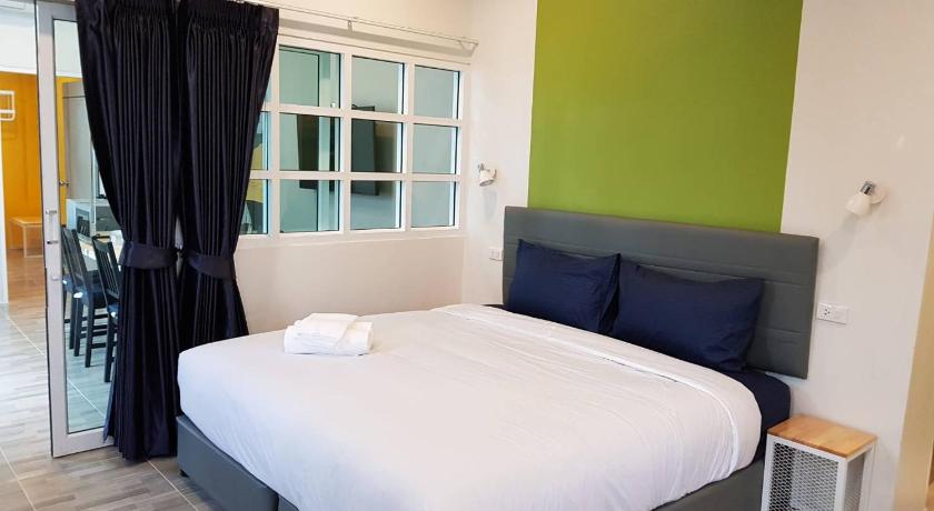 a bedroom with a bed and a dresser, The Cube Resort in Chanthaburi