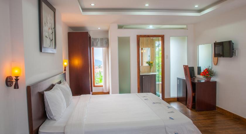 a bedroom with a large bed and a large window, Giai Dieu Melody Hotel in Dalat