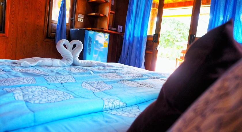a bedroom with a bed and a window, Baansuan Resort in Surat Thani
