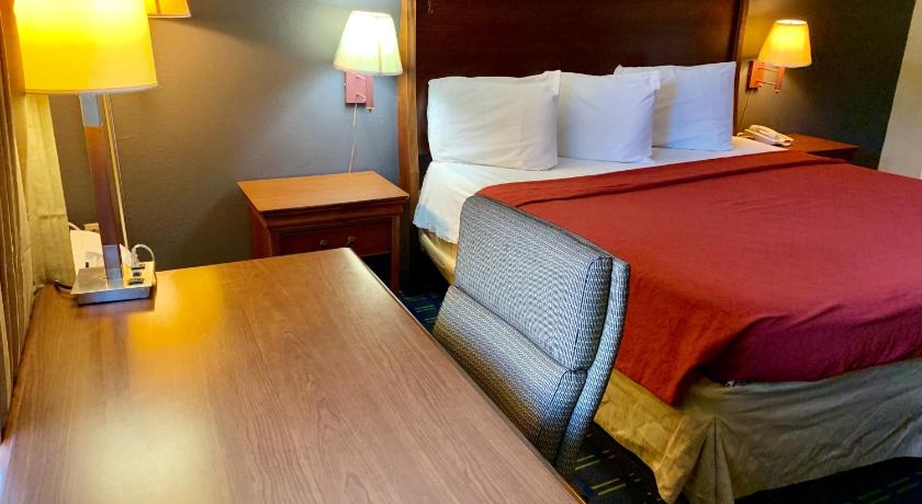 a hotel room with two beds and a lamp, Value Lodge - Gainesville in Gainesville (FL)