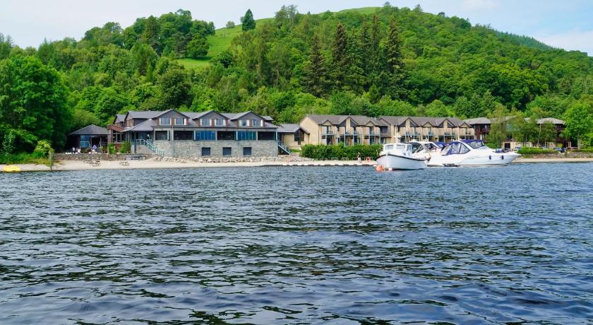 a boat traveling down a body of water, The Lodge on Loch Lomond Hotel in Luss