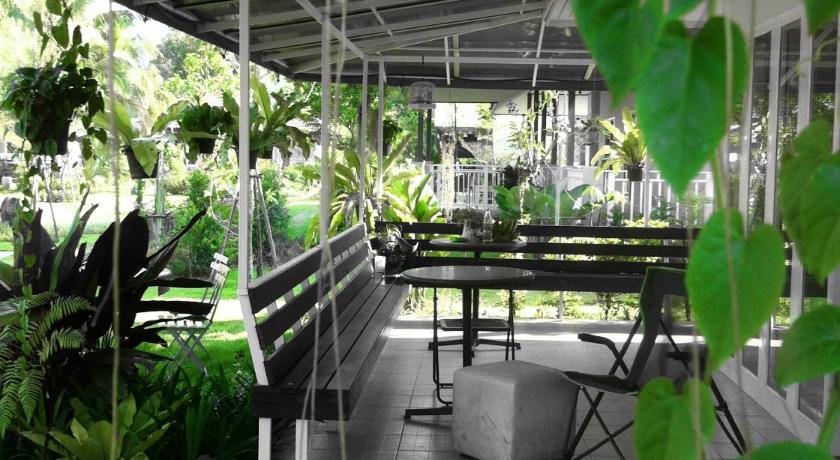 a patio area with benches and plants in it, Khao Yai Cottage in Khao Yai