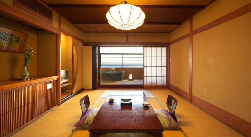 a room with a table, chairs, and a window, Ryokan Senoumi in Izu
