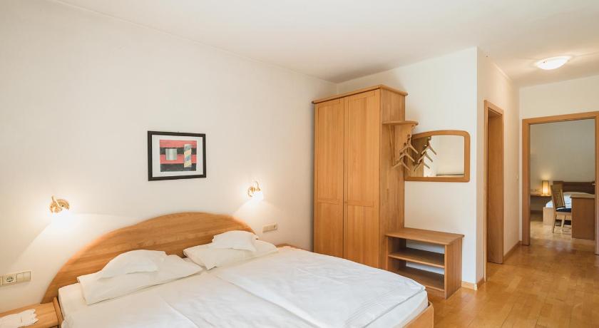 a bedroom with a bed and a dresser, Guesthouse St Nikolaus in Ultimo