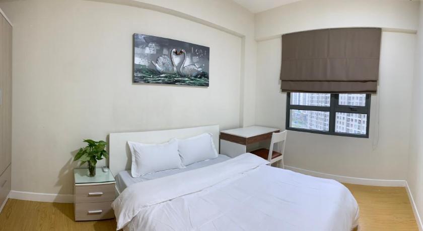 a white bed sitting in a room next to a wall, Masteri Apartment 2BR in Ho Chi Minh City