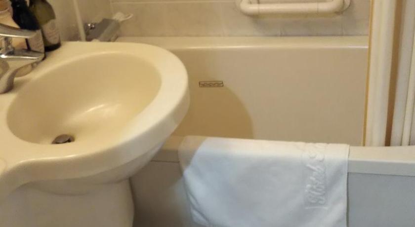 a white toilet sitting next to a bath tub, Hotel Hokke Club Kagoshima in Kagoshima