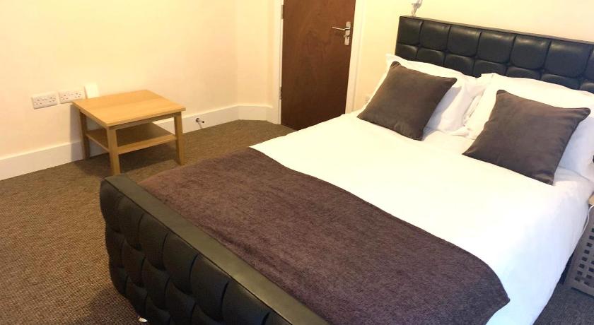 a hotel room with a bed, chair and a lamp, Serviced Accommodations in Luton