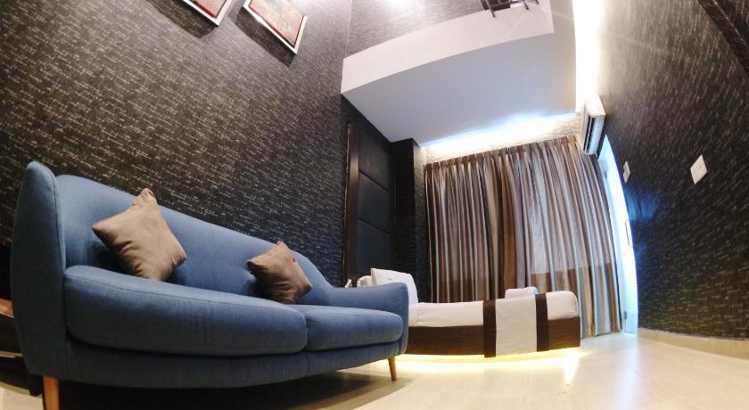 a living room with a couch and a chair, HereHotel in Johor Bahru