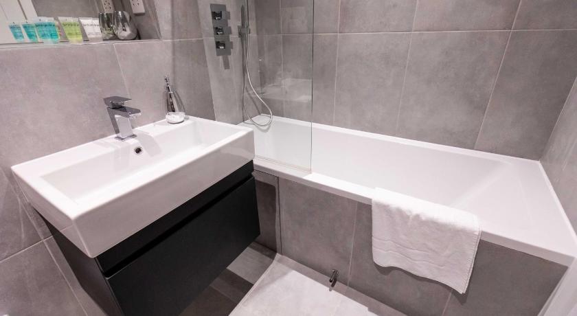 a white bath tub sitting next to a white sink, Watford Apartments Century House, Self Contained Units in London