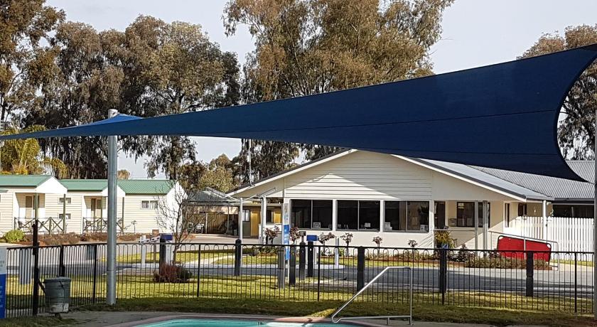 a blue and white house with a blue umbrella, Boomerang Way Tourist Park in Tocumwal