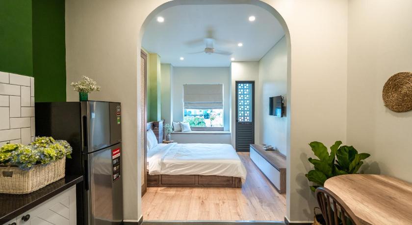 a kitchen with a refrigerator, stove, sink and a television, Mecozy Apartel in Ho Chi Minh City