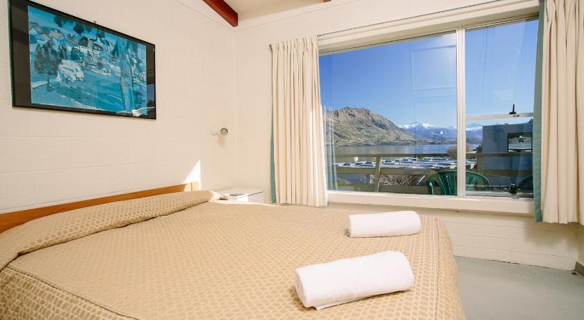 a hotel room with a bed and a window, Panorama Court in Wanaka