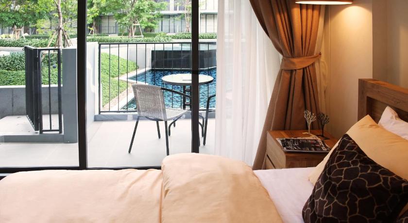 a room with a bed, chair, table and a window, The Valley Khaoyai By AK in Khao Yai