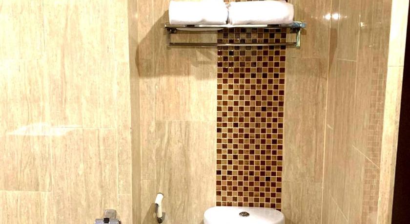 a bathroom with a toilet and a shower stall, Pacific Hotel Ambon in Ambon