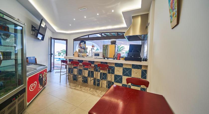 a kitchen with a tv and a table in it, Hotel Bajamar Ancladero Playa in Nerja