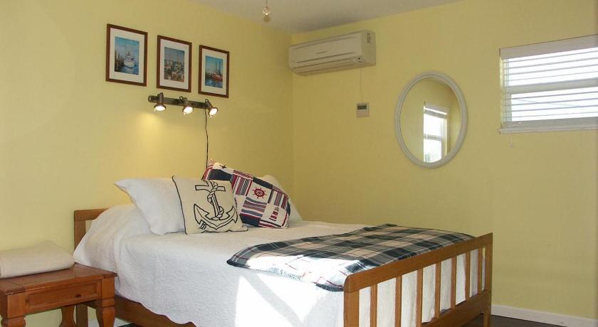 a bedroom with a bed and a lamp on the wall, Flagler Beach Motel and Vacation Rentals in Flagler Beach (FL)