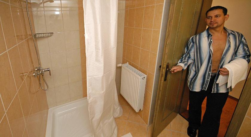 a man standing in a bathroom next to a shower, Hotel Bavaria in Abda