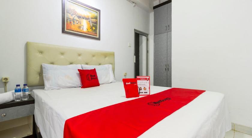 a hotel room with two beds and a table, RedDoorz near Gajah Mada Plaza 2 in Jakarta