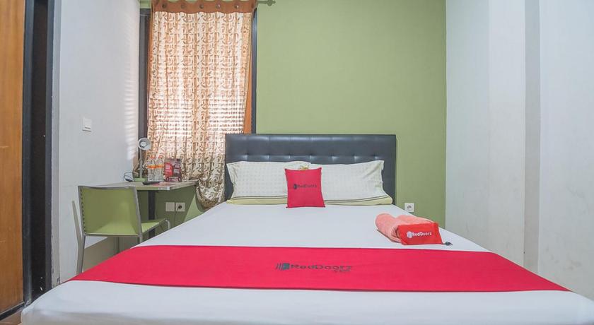 a bed room with a white bedspread and pillows, RedDoorz Syariah near Krida Nusantara in Bandung