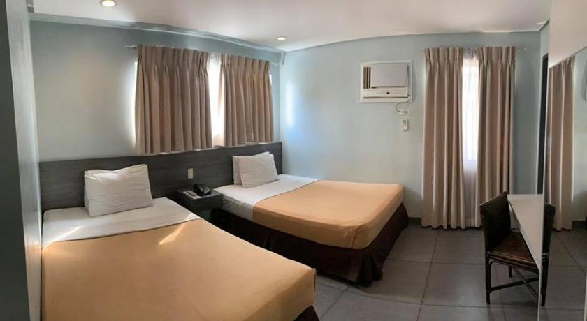 a hotel room with two beds and a television, Cebu R Hotel - Mabolo in Cebu