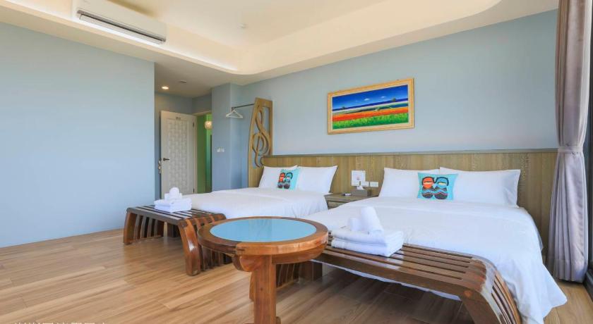 a bedroom with a bed, chair, table and a lamp, Pon Pon Wu Homestay in Penghu