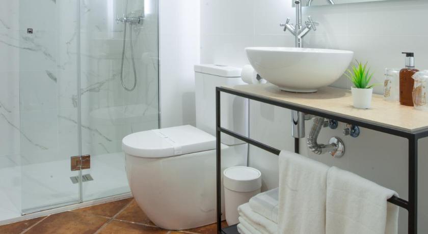 a white toilet sitting next to a bath tub in a bathroom, Hotel Jaime I in Mora de Rubielos