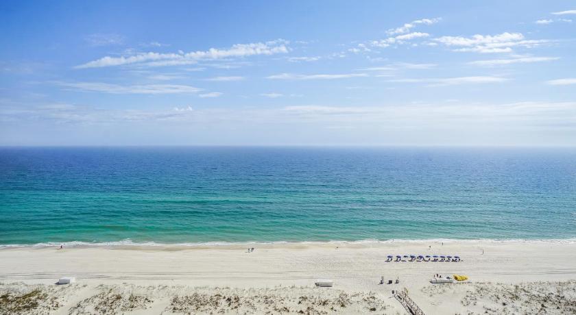 a beach with a beach umbrella on the beach, Portofino Island Resort in Pensacola Beach (FL)
