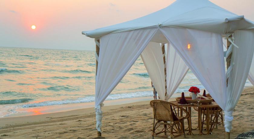 a table with a blanket on top of it on a beach, Saint Tropez Beach Resort Hotel in Chanthaburi