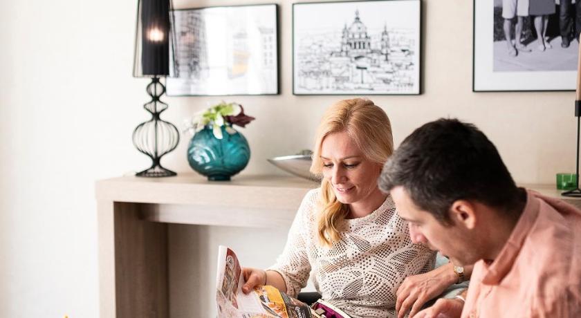 a man and a woman reading a book together, The Three Corners Lifestyle Hotel in Budapest