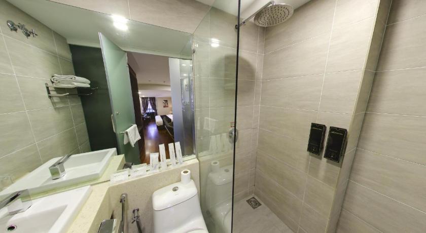 a woman standing in front of a bathroom mirror, Manhattan Business Hotel Damansara Perdana in Kuala Lumpur