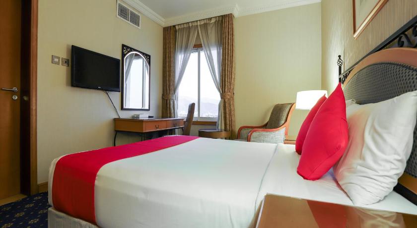 a hotel room with a bed, chair, and nightstand, OYO 328 City Plaza Hotel in Fujairah