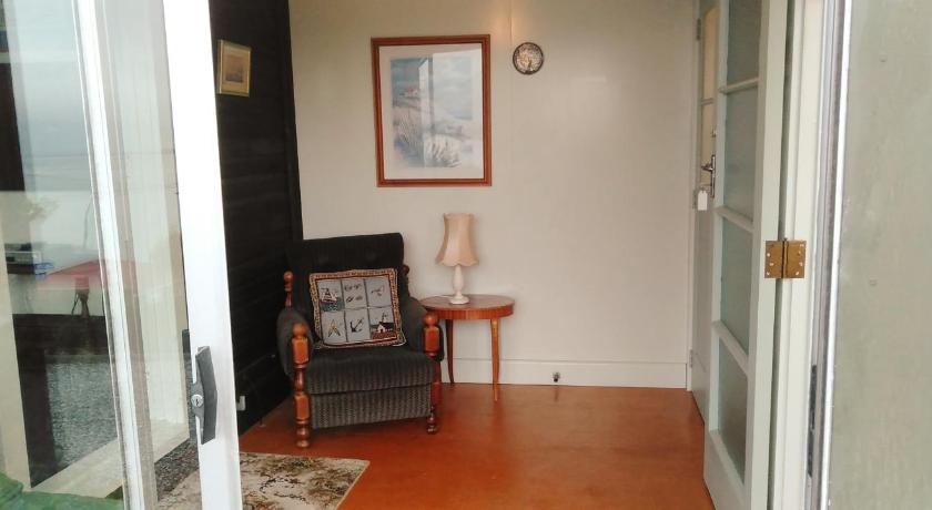a living room with a couch and a chair, Haven on Haven in Moeraki