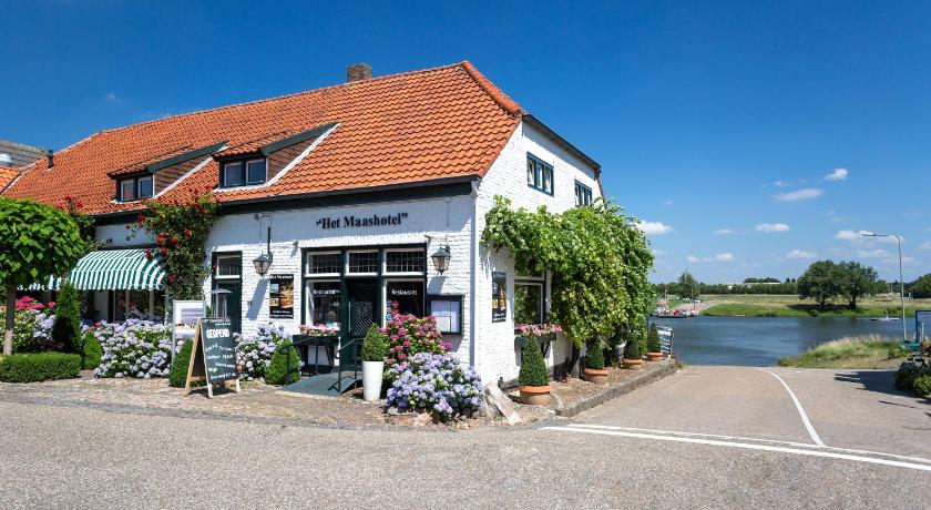 a house that has a boat parked in front of it, Het Maashotel in Horst aan de Maas