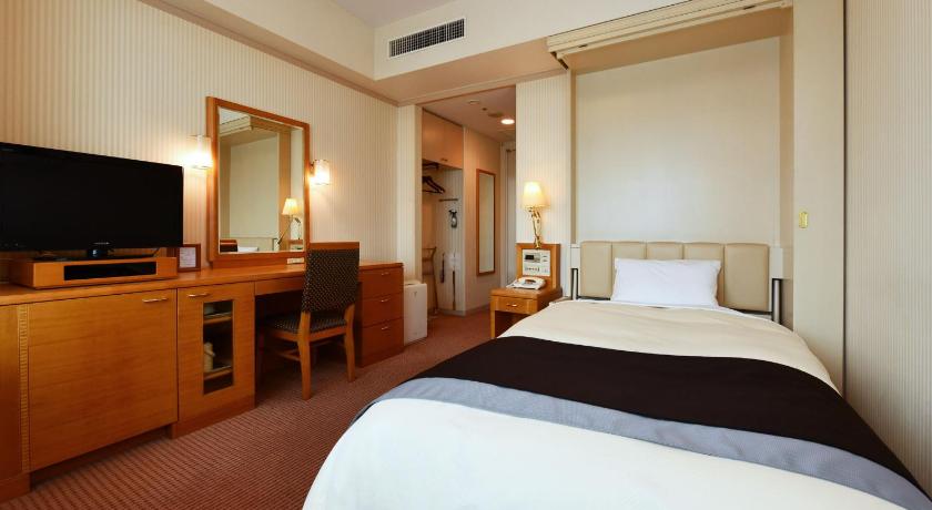 a hotel room with two beds and a television, The Crest Hotel Kashiwa in Kashiwa