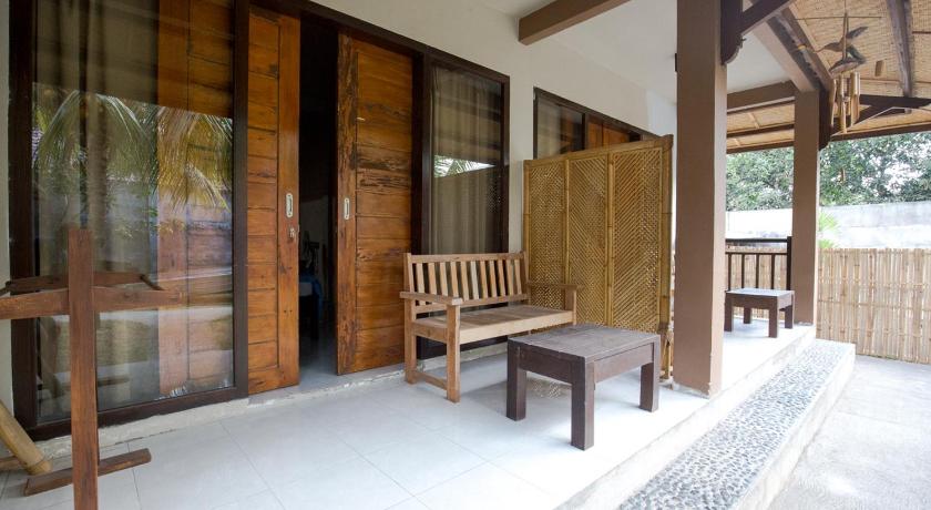 a wooden bench sitting in front of a wooden wall, Asoka Homestay in Lombok
