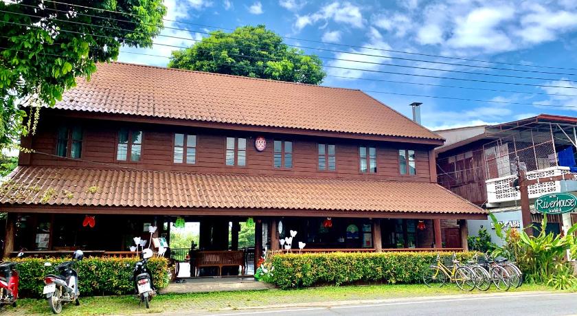 a large building with a clock on the front of it, Riverhouse Hotel (The Teak House) in Mae Hong Son