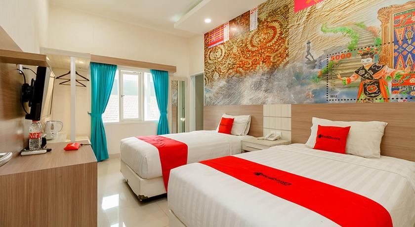 a hotel room with two beds and a painting on the wall, Poin Phila Hotel in Bandung