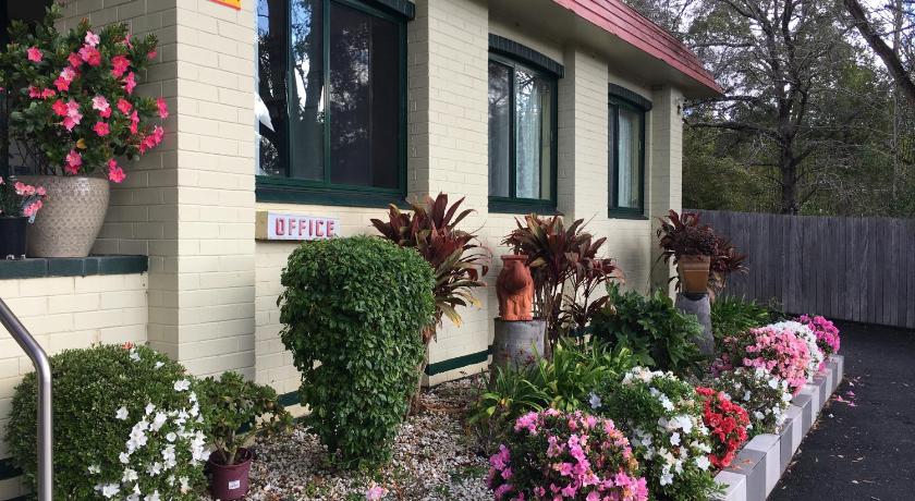 a garden filled with flowers next to a building, Major Innes Motel in Port Macquarie