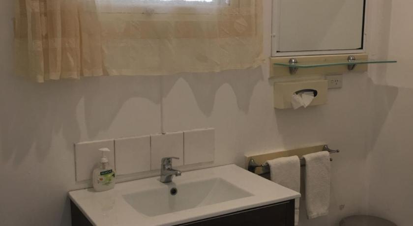 a bathroom with a sink, toilet, and mirror, Major Innes Motel in Port Macquarie