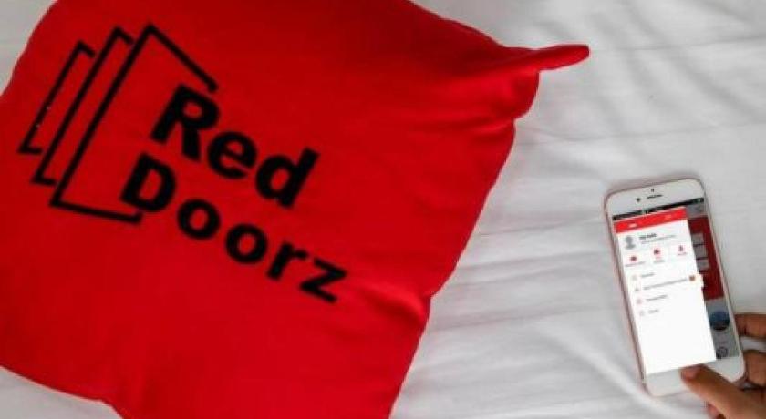 a person holding a cell phone in front of a flag, RedDoorz near TVRI Gorontalo in Gorontalo