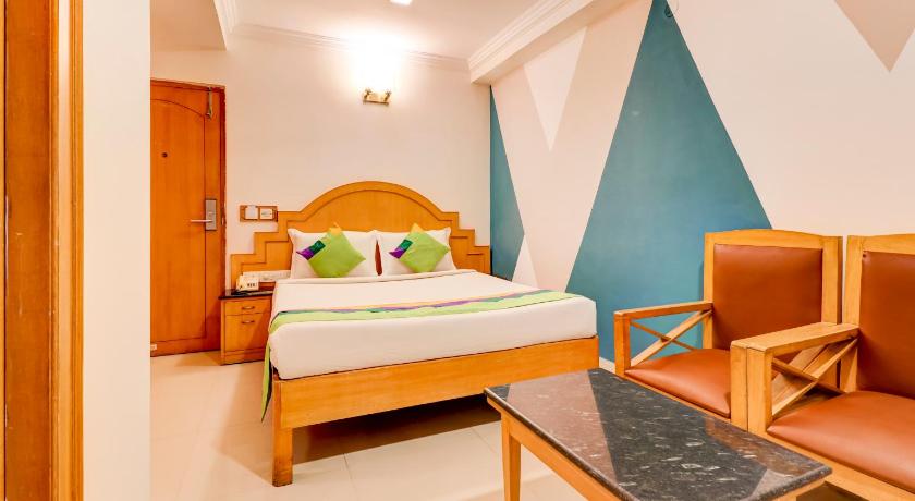 a bedroom with a bed, desk, chair, and lamp, Treebo Trend Terminus in Bangalore