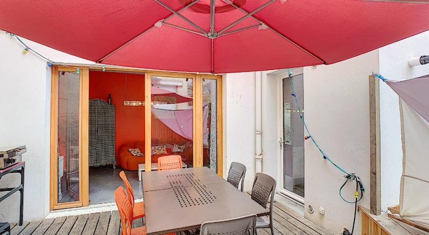 a red umbrella sitting on top of a wooden table, La Maison de Sebea in Bordeaux