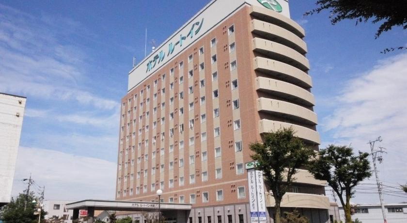 a large building with a clock on the front of it, Hotel Route Inn Suzuka in Suzuka